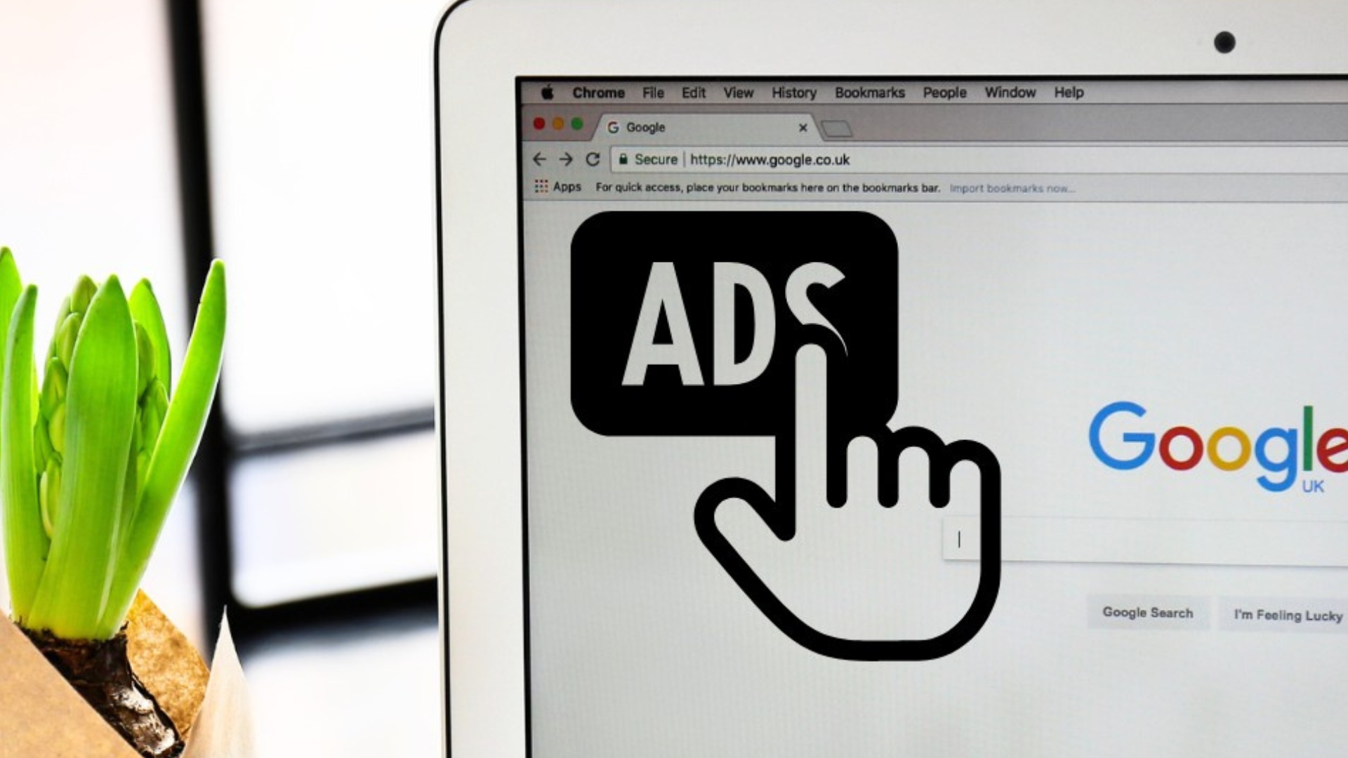 Laptopbildschirm zeigt Google-Startseite und ein Symbol mit der Aufschrift 'ADS' und einer Hand, die darauf zeigt