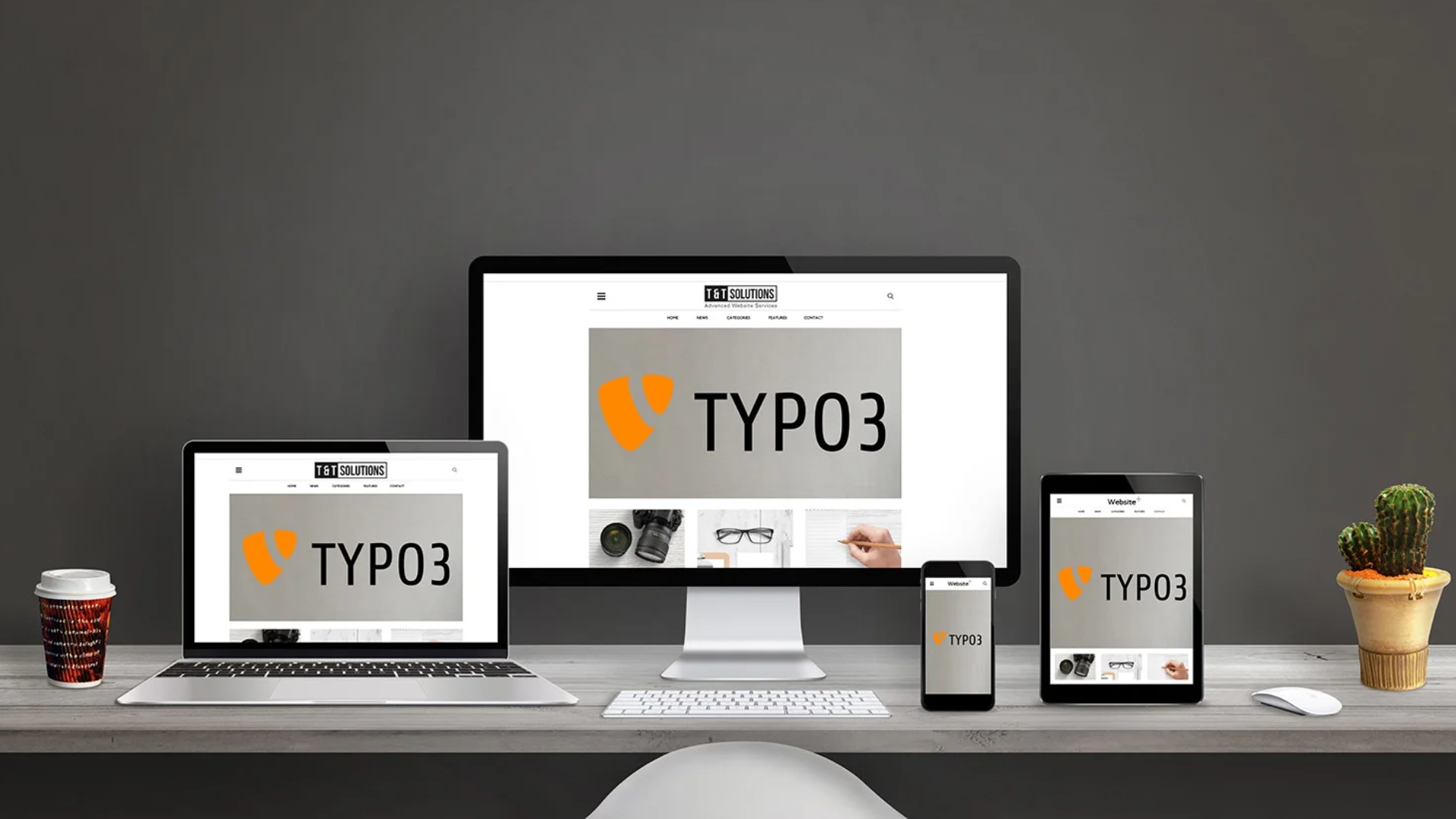 TYPO3-Logo auf Bildschirm, Laptop, Tablet und Smartphone auf einem Schreibtisch mit Kaffeebecher und Kaktus